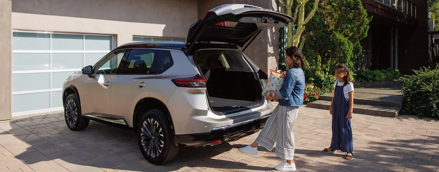 Woman opening the liftgate on a silver 2026 Nissan Rogue