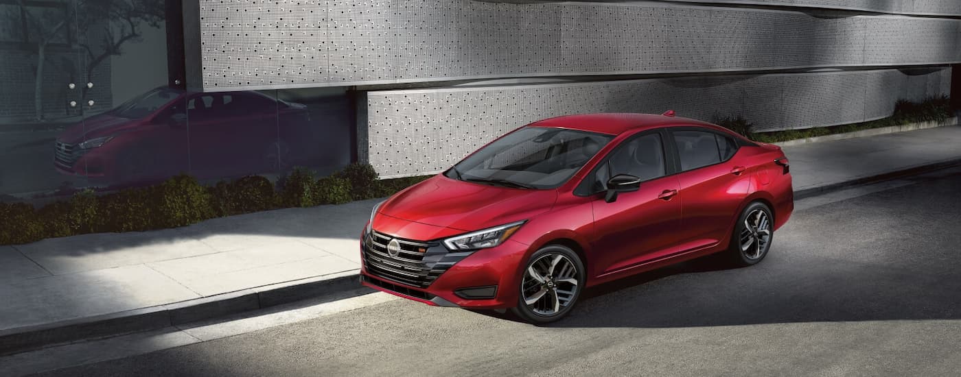 Red 2026 Nissan Versa driving on a city highway