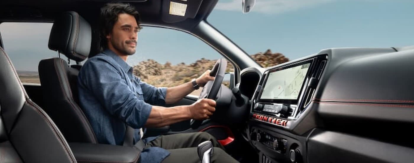 An person driving in a 2026 Nissan Frontier.