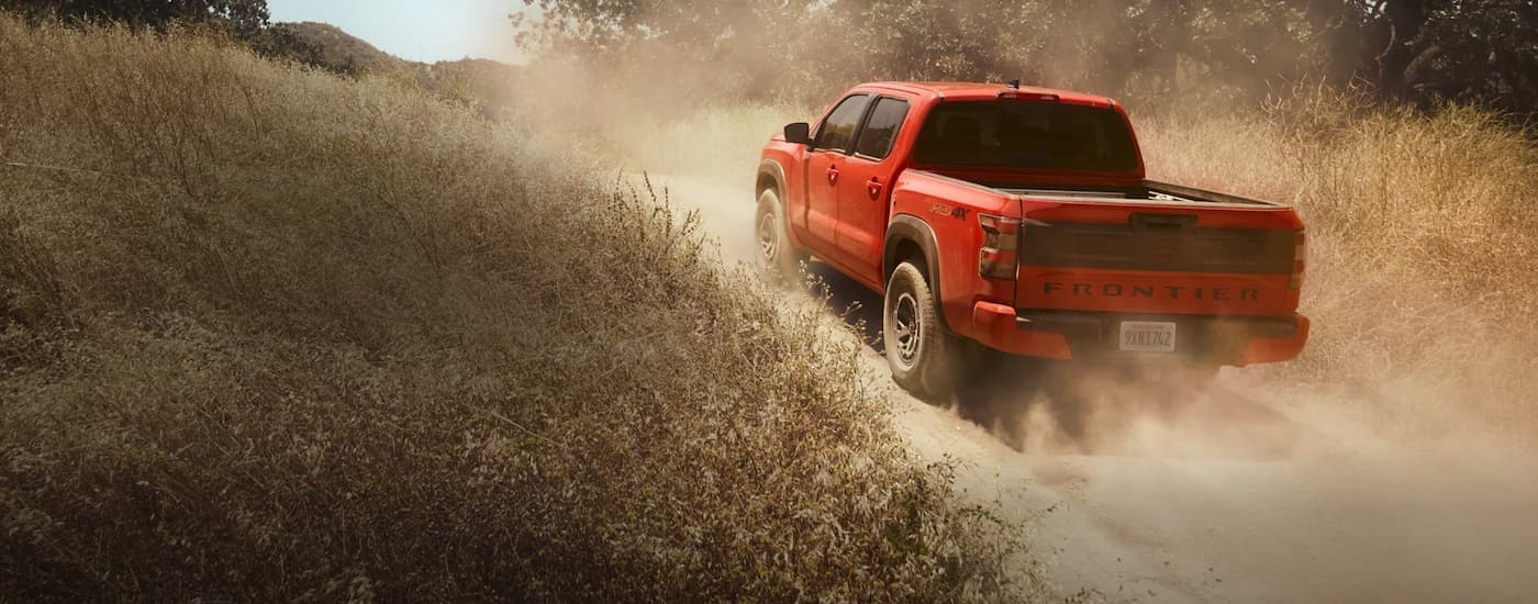 An orange 2026 Nissan Frontier off-roading.