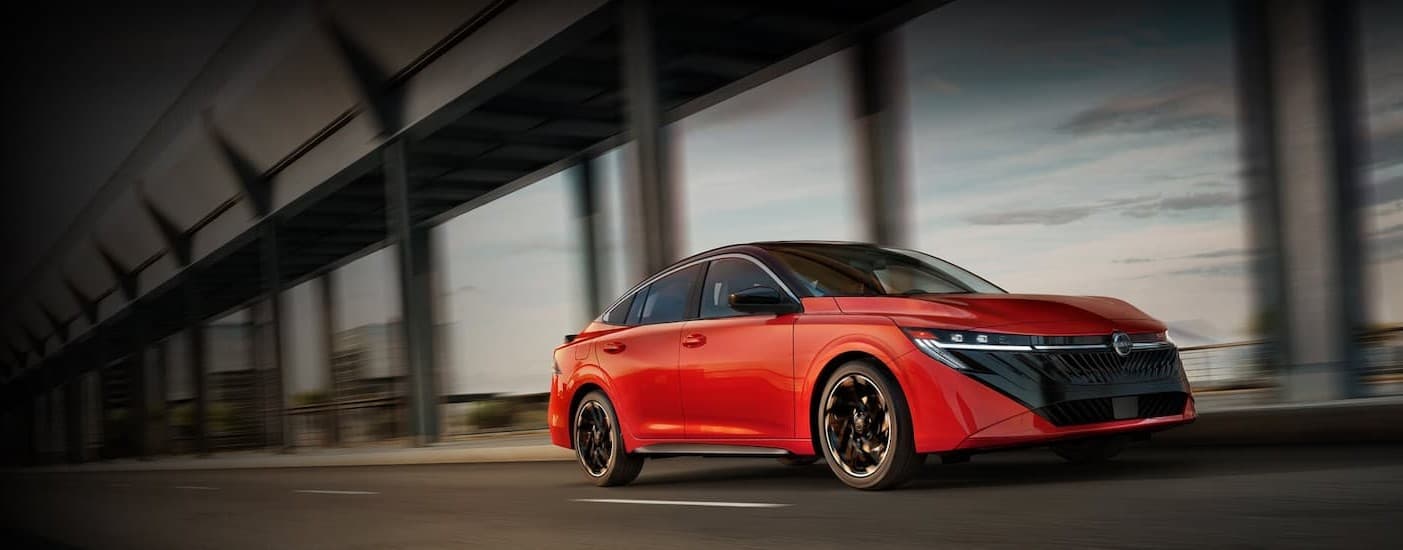 A red 2026 Nissan Sentra driving in a city.